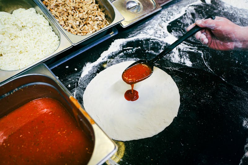 Pizza being prepared fresh in the kitchen